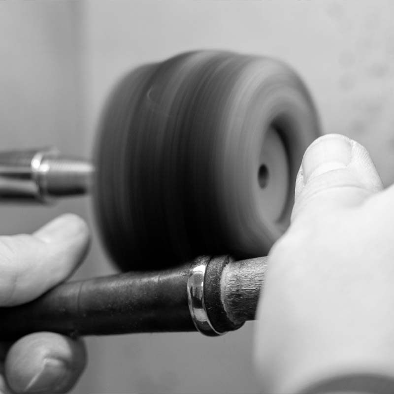 Ein Ring wird durch den Goldschmied poliert und aufbereitet.